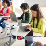 alunos em sala de aula utilizando computadores