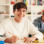 aluno em sala de aula sorrindo para a foto