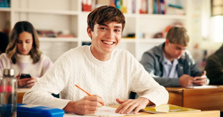 aluno em sala de aula sorrindo para a foto