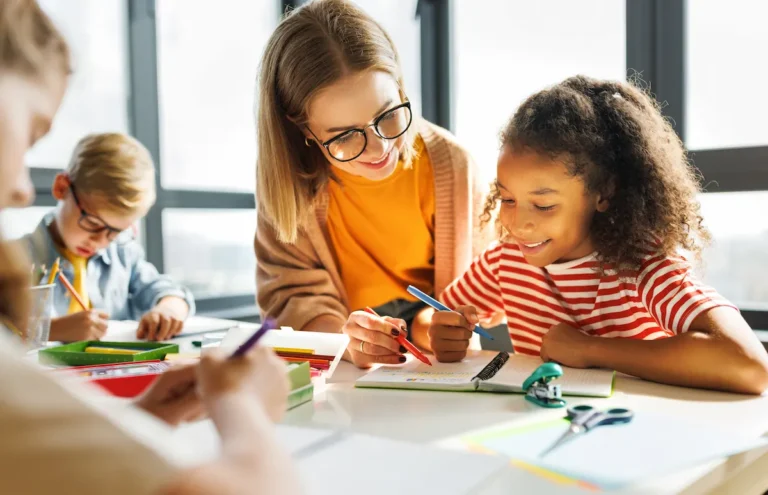 professora ajudando aluna na carteira da sala de aula